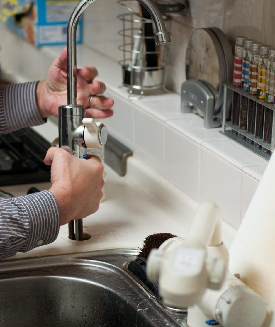 Plumber installing a kitchen faucet