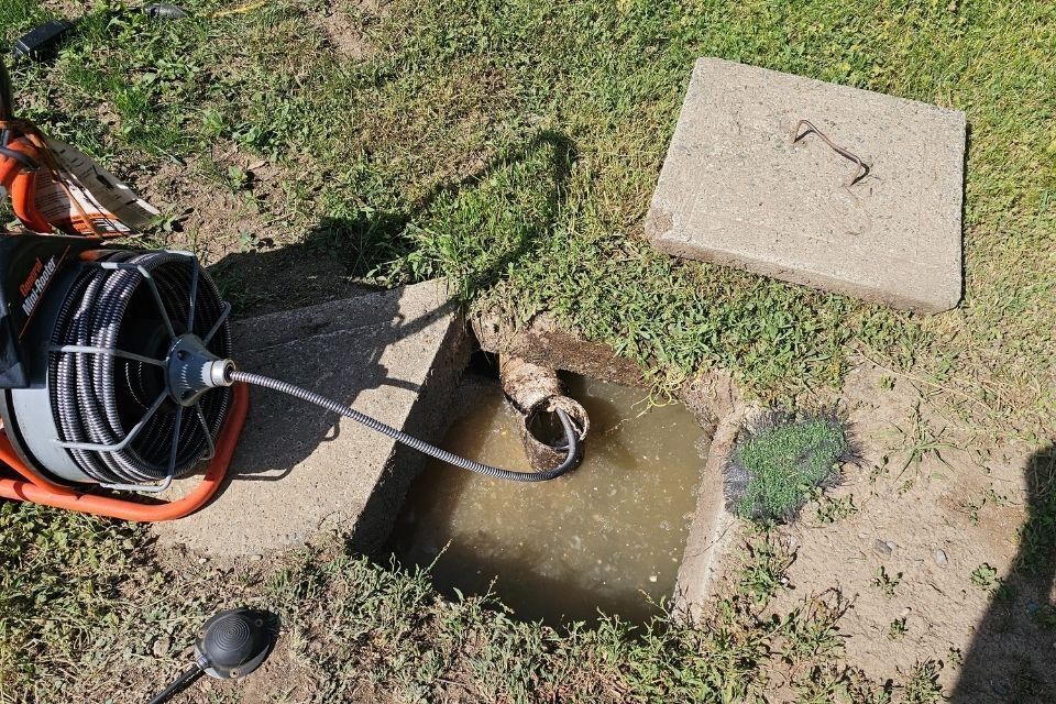 Drain cleaning machine working on an outdoor drain